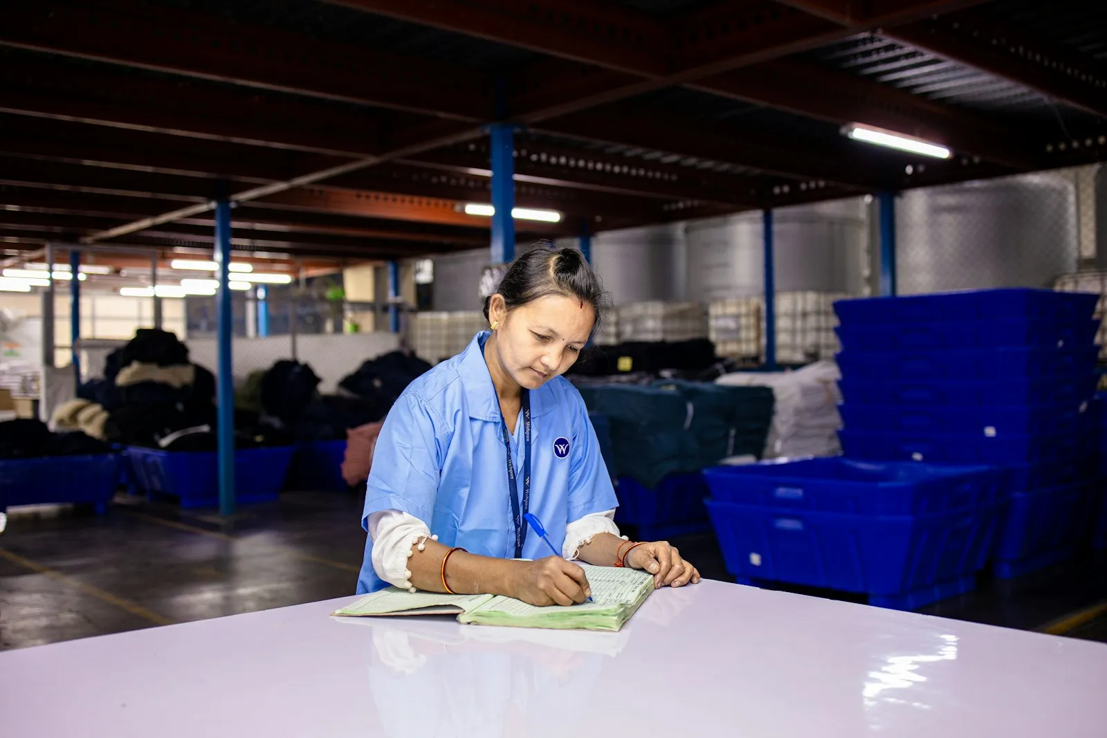Operaria anotando datos de producción en la planta